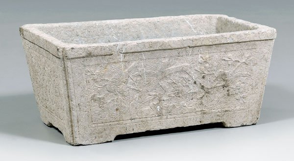 Chinese gray stone basin,: footed rectangular form with canted corners, each side with carved panel of birds, trees, two drain holes in base, 11 x 25-1/2 x 14 in. Old chips to rim and feet.