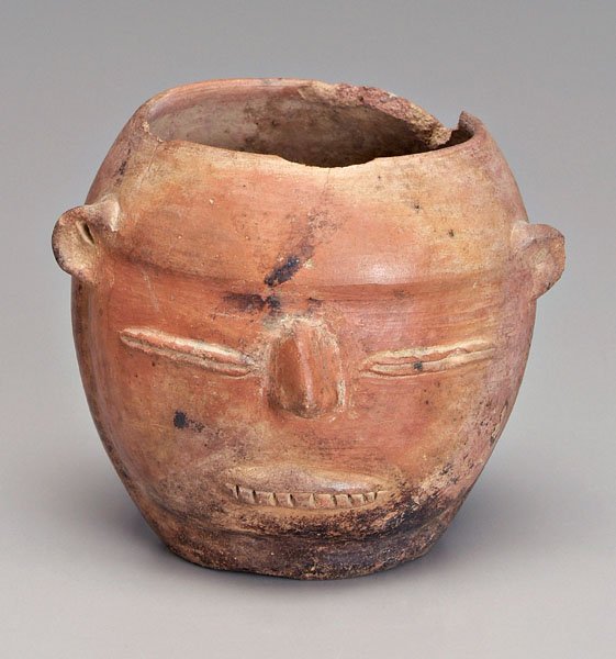 Nayarit earthenware effigy vessel,: rounded form with slit eyes and incised teeth, Western Mexico, 100 B.C.-300 A.D., 4-5/8 in. Large rim chips, base wear, cracks and surface losses. Provenance: Private Collection, Winston-Salem, North