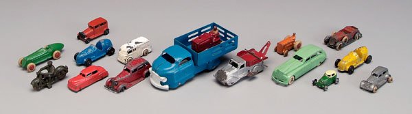 16 toy vehicles:: 14 cast metal, two sheet metal, several Tootsie Toys, one wind-up wrecker, one sheet metal blue truck, 2-1/8 in. to 7-1/2 in. Some lacking tires or with damaged tires, scattered paint chips and losses