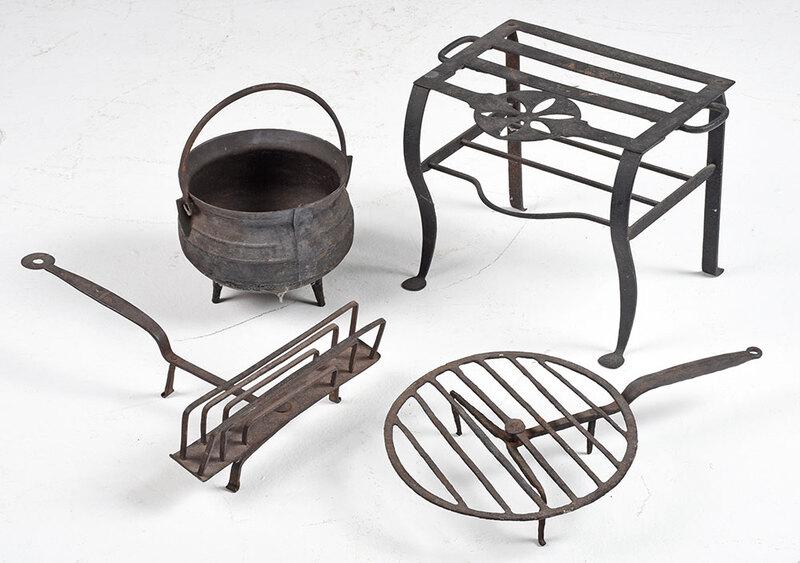 Four Wrought Iron Fireplace Cooking Implements: probably American, 19th century, trivet with pinwheel design, 13 in.; three footed kettle with bail handle, 8 in.; toasting rack, 17 in.; circular trivet, 20 in. - Provenance: Property from the Collec