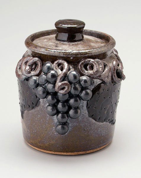 Lanier Meaders stoneware beanpot: (1917-1998, White County, Georgia), brown alkaline glaze, applied grapes, vines and leaves, incised on base "Lanier Meaders", 6 in. Provenance: Zully Smith Craft Shop, 1979
