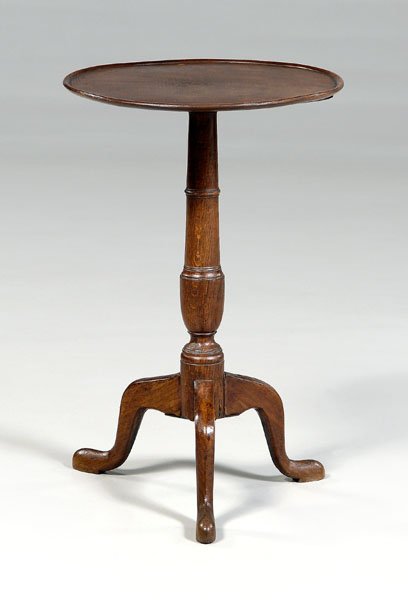Georgian dish-top candle stand,: oak and beech, tripod base with slipper feet, British, 19th century, 27 x 18 x 17-1/4 in. Repair to one leg at joint with support, scattered pest damage, top set with later pegs.