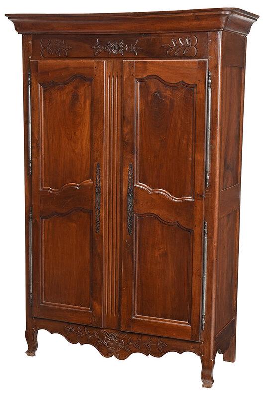 Provincial Louis XV Carved Walnut Armoire: French, late 18th century, removable cornice over leaf and rosette carved pediment above two paneled doors with steel hinges and escutcheons, open interior, leaf and urn carved skirt, paneled case sid