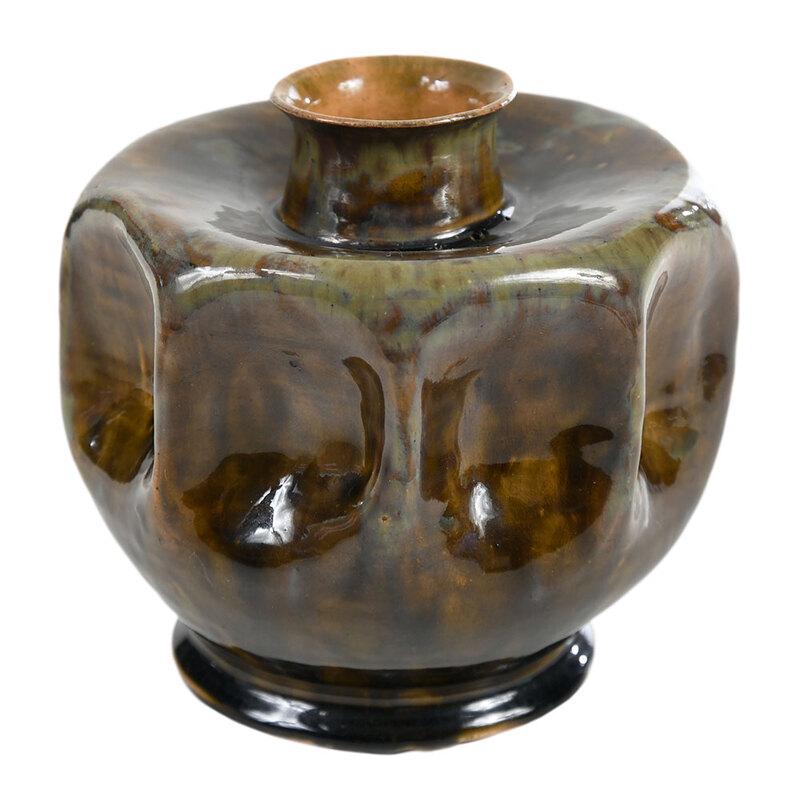 George E. Ohr Art Pottery Vase: (Biloxi, Mississippi, circa 1898-1910) earthenware low vase form, runny yellowish brown glaze, green and rutile glaze highlights at shoulder, raised edges of body, and neck, black glaze around footed