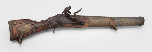 Flintlock blunderbuss,: extensive engraved brass mounts, probably middle eastern, 18th or early 19th century, 20-1/2 in. Stock with cracks and repairs, lacking several surface elements.
