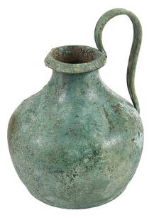 Etruscan Bronze Olpe with Gorgoneion Mask: possibly 5th century B.C., short pear form vessel with green patina, beaded overhanging rim with ovolo kymation decoration, high arching strap handle riveted under the rim, handle terminal with mask