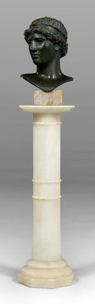 Classical bronze bust, pedestal: a Roman youth, [verdigris] patinated bronze on square marble base, 18-1/2 in., with 37-3/4 in. alabaster pedestal. Chip on proper right shoulder, dents in proper right cheek. Provenance: Estate of the