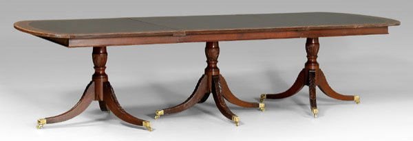 Federal style mahogany dining table,: three pedestals, each pedestal with banded mahogany top over leaf-carved support on carved saber legs with brass casters, 20th century construction, 30 x 120 (160 in. with two leaves) x 48 in. Good co