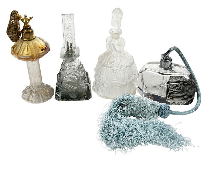 Four Frosted and Molded Glass Perfumes: Continental, 20th century, including figure of a woman wearing a hooped skirt, head stopper, attached label "Made in Czech Republic"; atomizer with column support and floral base; atomizer with clear 
