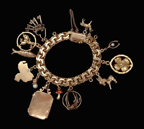 Gold charm bracelet,: 18 kt. yellow gold double-link bracelet with 12 charms: 10 kt. deer, wishbone with pearl, four-leaf clover with pearl; 14 kt. donkey, Scorpio, mushroom, locket, [small dents, scratches,] rabbit, fish,