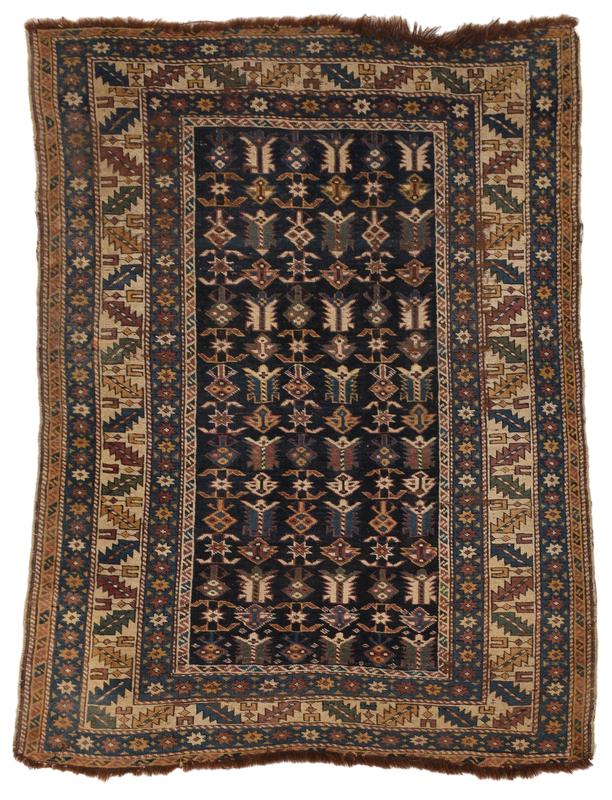 Kazak Rug: early 20th century, blue field with repeating rows of geometric florals, star border, leaf and wine glass motif, 5 ft. x 3 ft. 9 in. Provenance: Estate of T. Kenneth and Karin Ellis, "Stepping Stones"