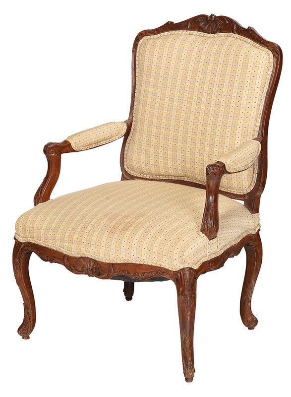 Louis XV Carved Beechwood Open Arm Chair: French, 19th century, with shell carved crest, leaf carved hand grips, carved legs and scrolled feet, pale yellow and blue modern upholstery, pinned construction, 38 x 27-1/2 x 22 in. Provenance: Esta