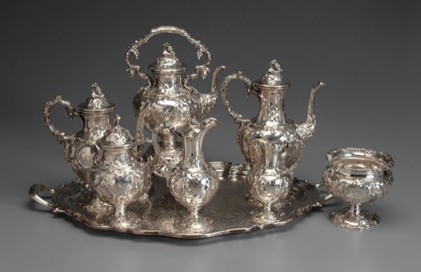 Seven-piece coin silver tea service,: urn forms and finials, chased grape and vine decoration: 16-1/2 in. hot water kettle with matching coffeepot, teapot, ewer, sugar, creamer and waste, all with matching "VSK" monograms, marks for Ball,