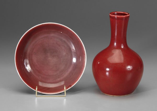 Two Chinese copper-red pieces:: bottle vase, rich strawberry with darker speckling, white rim, base with crackled white glaze, 18th century, 9-1/4 in., [crazing, minor grime, minor scratches;] bowl with liver-red interior, white rim