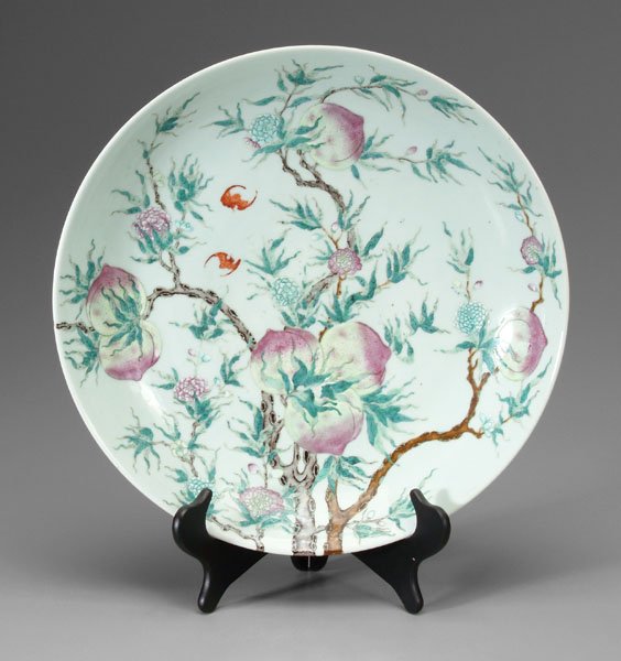 Chinese [famille rose] charger,: interior and exterior with two iron-red bats flying between branches bearing peaches, flowers, branches, base with blue Qianlong seal mark (1736-1795), 19th century, 3-1/4 x 18-1/4 in. Wear and losses