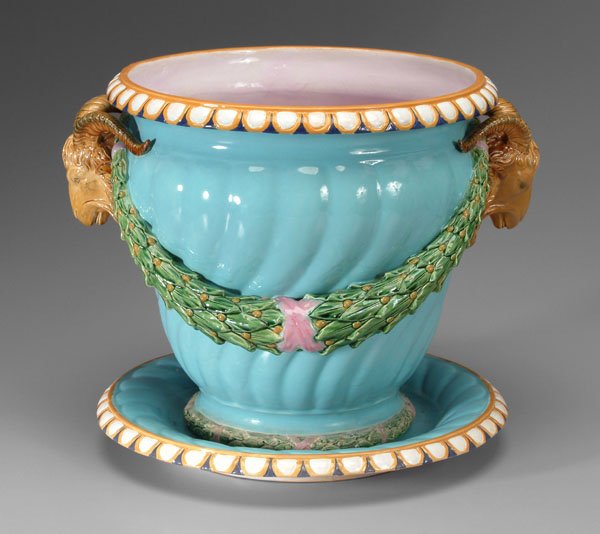 Large Mintons jardinière,: spiraled with leaf and berry swags flanked by rams' heads, orange and blue petal borders, 14-1/2 in., matching under plate with impressed mark "Mintons", diamond in circle and "1144" and "16", 17 in.,