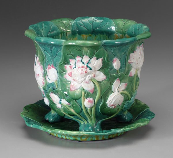 Mintons jardinière with under plate:: water lilies in heavy relief, footed base, 9-3/4 in., matching under plate, 13-1/2 in., both with impressed Mintons marks and "198", late 19th century. Jardiniere in good condition, minor mineral stai