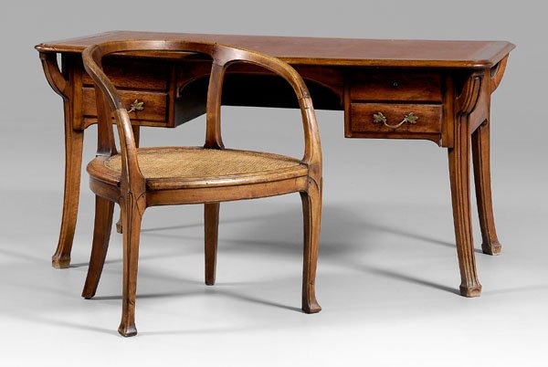 French Art Nouveau writing desk,: leather top, four dovetailed drawers with beech linings on carved legs, possibly Louis Marjorelle, French, late 19th century, 29-1/2 x 59 x 31-1/4 in.; together with a similar carved fruitwood armchai