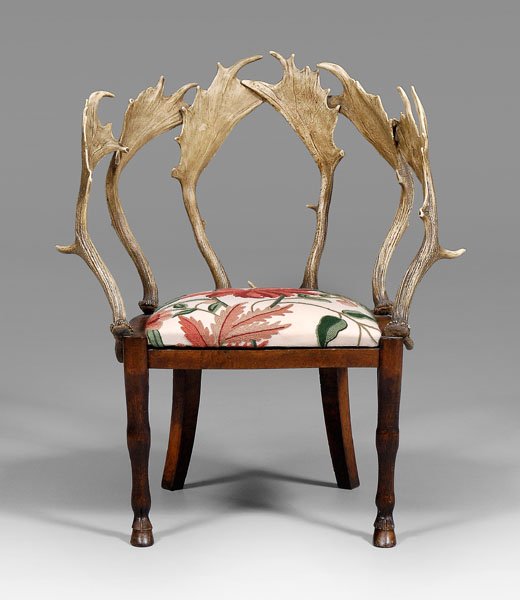 Whimsical carved oak and antler chair,: back composed of six deer antlers, crewelwork-upholstered slip seat on carved oak frame with carved hairy legs with hoof feet, British, late 19th century, 35 x 30 x 21-1/2 in. Good condition overall, 