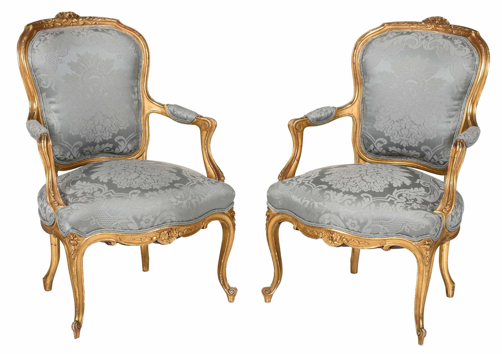 Pair Louis XV Style Carved Gilt Armchairs: French or Italian, late 19th/early 20th century, each carved frame with floral crest and skirt, cabriole legs with scrolled feet, blue silk damask upholstery, 35-1/2 x 24 x 17 in. Provenance: Keil's A