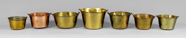 Seven brass and copper kettles,