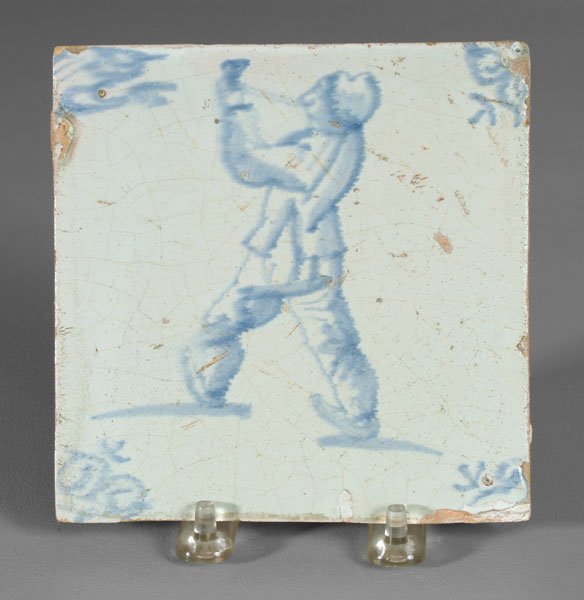 Dutch tile, man smoking,: ox head corners flanking figure of man walking and smoking, Dutch, late 17th century, 5 in. square. Corner chips and losses, surface with overall light crazing. Provenance: Mark and Marjorie Allen Ant