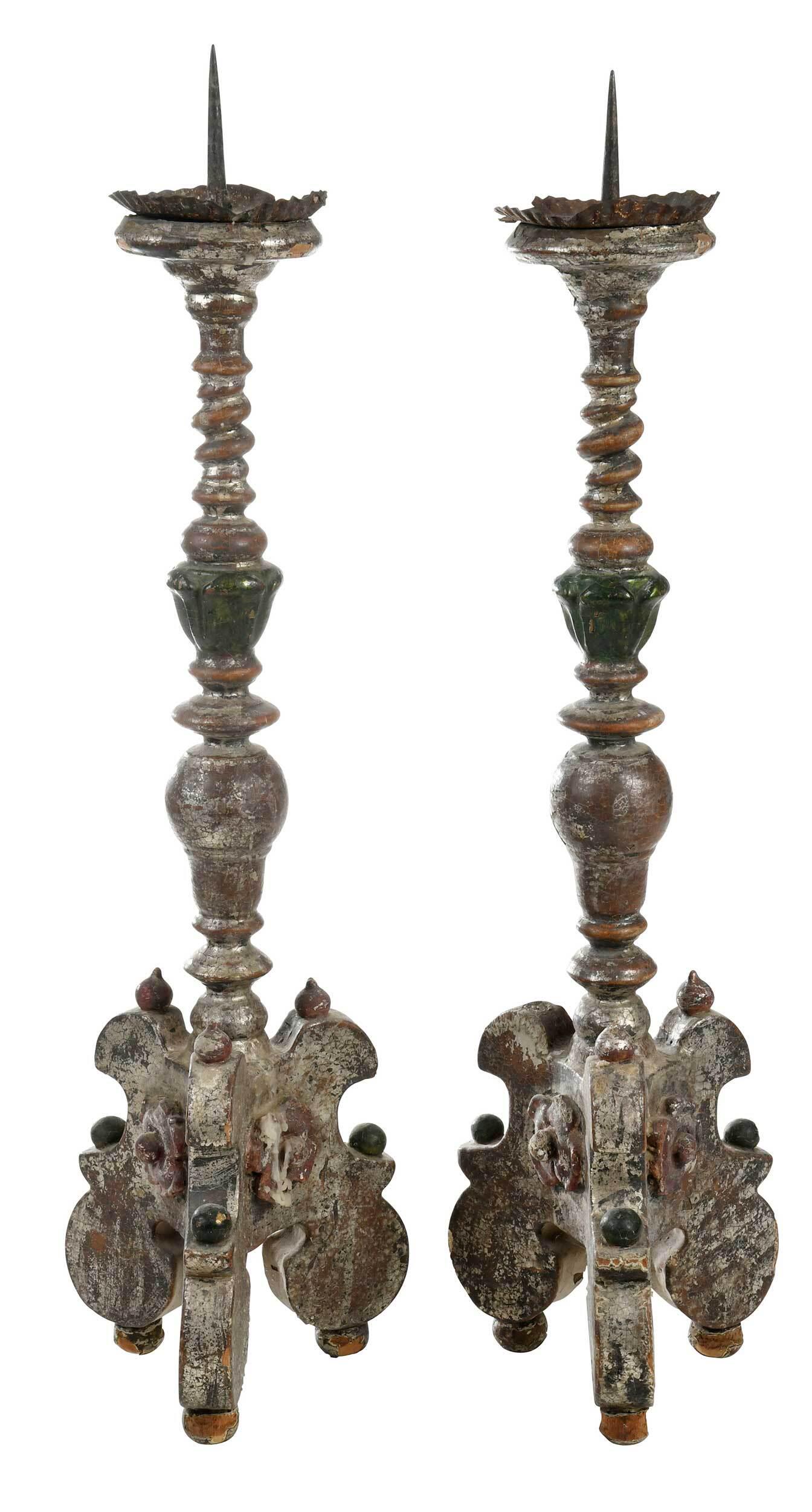 Pair Italian Baroque/Baroque Style Candlesticks: each with tin candle cup with crimped rim, carved and turned central shafts on trifid base with ball feet, carved ball and floral elements, remnants of old paint surface in red, green, and silver, eac