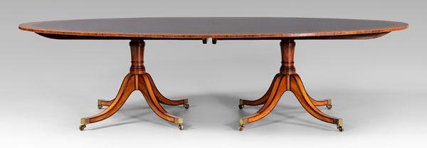 George III style two-pedestal: dining table, oval satinwood-banded top, each pedestal with four saber legs, 28-3/4 x 56 x 112 in. (156 in. with leaves), with two leaves, custom made in England by William H. Tillman, 1984. Excellent