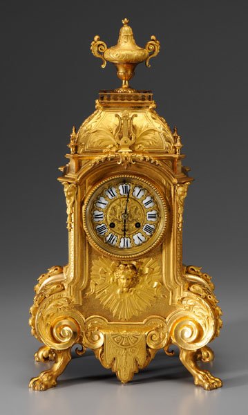 Louis Philippe doré bronze clock,: cast rococo elements including foliage, shells, woman's head surrounded by sunburst, bellflowers, masks, lyres, urn pediment, four paw feet, bright and matte gilding, Japy Freres movement, back plate 