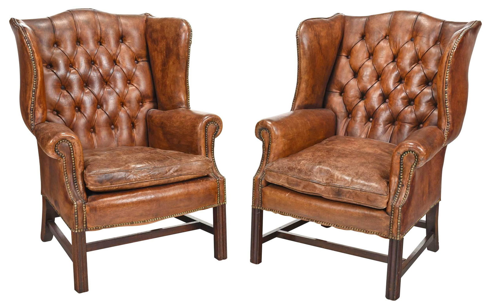 Pair Chippendale Style Leather Upholstered Wing Chairs: 20th century, each with brown leather upholstery, tufted back, loose seat cushions, set with brass tacks, on molded square legs with stretchers, 41 x 30 x 26 in. Provenance: Private Bluffton, South Ca