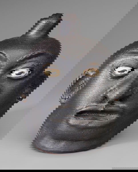 Lanier Meaders Black Face Jug: Georgia, 20th century, stoneware with dark gunmetal glaze, bulging ceramic eyes, large pronounced mouth, chin and nose, holes in earlobes, base incised "Lanier Meaders", (White County, Georgia, 1917-1