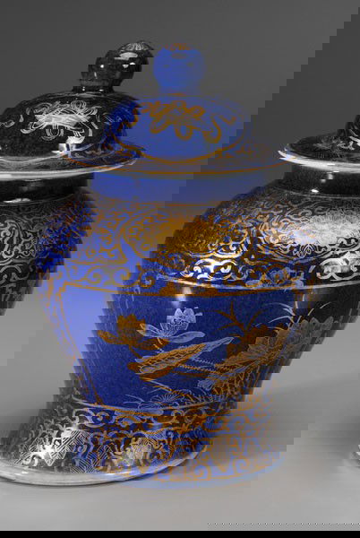 Powder Blue Lidded Jar: Chinese, 19th century, baluster form, gilt cartouches of flowers between [ruyi-] head and leaf borders, base with two blue concentric circles, 8 in., sleeve on lid with two chips (largest 1/2 in.), mi