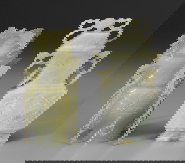 Two Hardstone Lidded Urns: Chinese, 20th century, translucent green stone, baluster form, dragon and lingzhi fungus flanges with rings, chains ending in fish, body with floral border, 6 in., [minor gouges as made;] opaque mottl