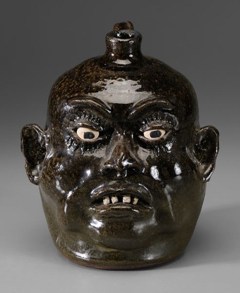 Lanier Meaders Face Jug: Georgia, 20th century, stoneware with glossy-to-matte olive glaze, ceramic eyes and teeth, base marked in script "Lanier Meaders" (White County, Georgia, 1917-1998), 9-3/4 in., excellent condition, no
