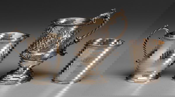 Coin Silver Mugs, Cup: American, 19th century, one Philadelphia mug with floral decoration; one New York City mug, 8.67 oz.T.; one unmarked cup, most with monogram, (three pieces); detailed list available Provenance: Collec