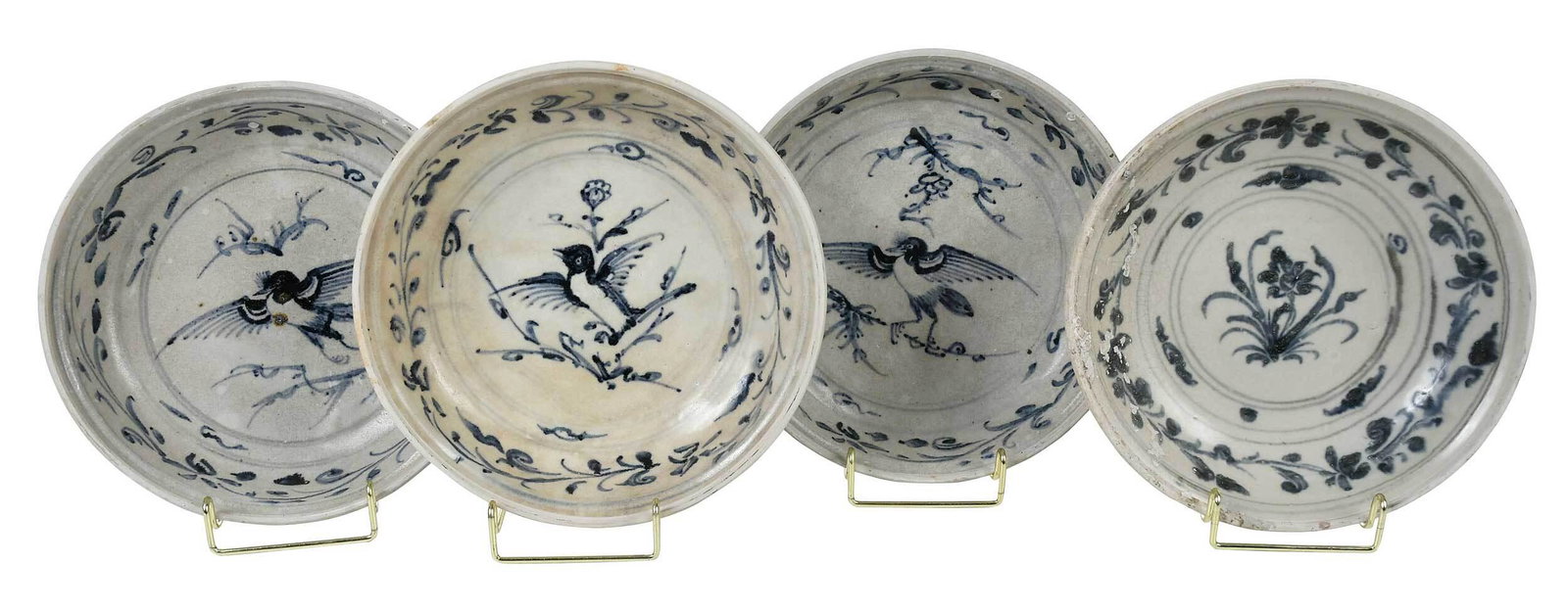 Four Vietnamese Hoi An Hoard Ceramic Chargers: probably 15th century, three painted at the center with a flying songbird; three painted at the center with a floral sprig, all with labels attached, each approximate 2 x 9-1/2 in. Provenance: Butterf