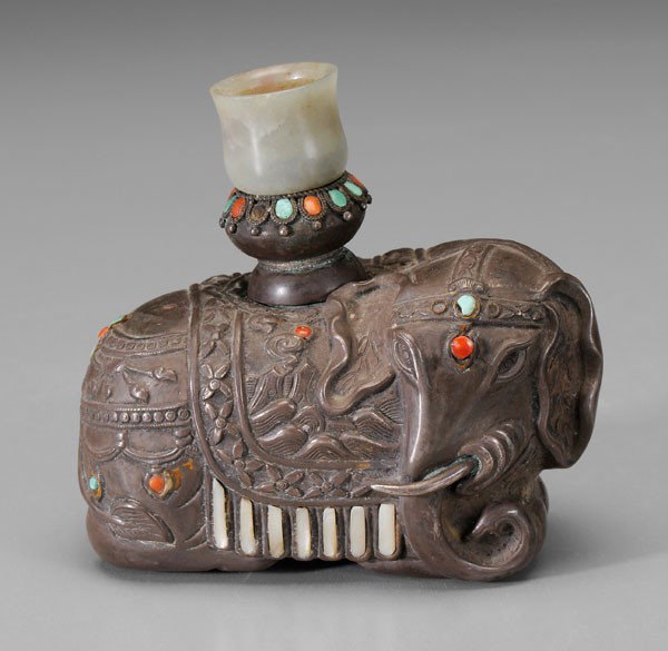Embellished Silver Elephant Vessel: Chinese, late 19th/early 20th century, recumbent caparisoned beast with inlaid turquoise, coral and mother-of-pearl, repoussé work, central hole on back fitted with stopper/funnel with jade mouth, po