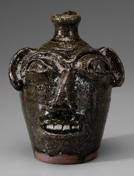 B. B. Craig Face Jug: (Catawba County, North Carolina, 1914-2002), sandy alkaline glaze, broken-china teeth, base stamped "BB Craig, Vale, NC", 8 in., excellent condition, minor surface anomalies as made Provenance: North 