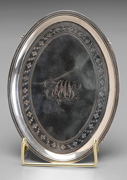 George III English Silver Teapot Stand: London, 1789, oval with engraved zigzag and floral borders, scroll feet, marks for Elizabeth Jones, .925 fine, monogram, 4.64 oz.T., 3/4 x 6-3/4 x 5 in., small dent, light scratches Provenance: Privat
