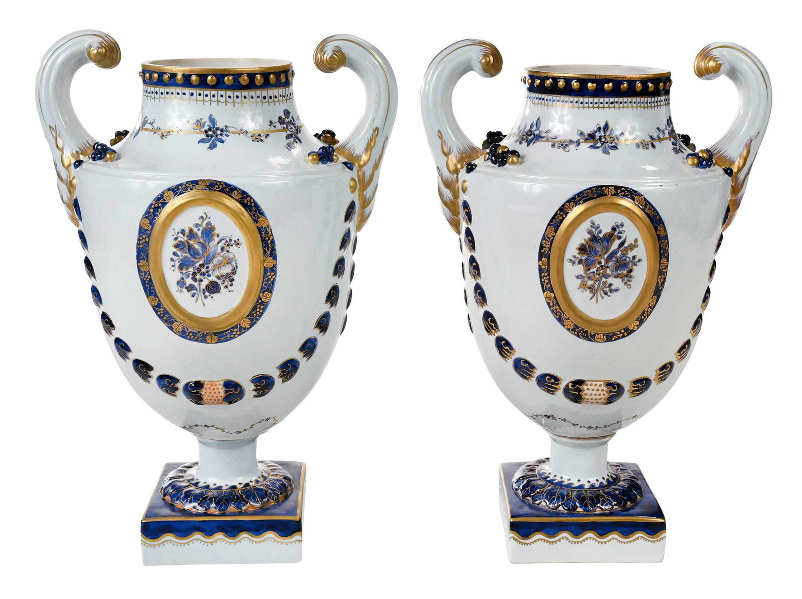 Pair of Mottahedeh Export Style Porcelain Urns: 20th century, "pistol handled" urns modeled after a Marieberg type, cobalt blue enamel and gilt decorated on each side with a foliate medallion, molded bellflower swags, Mottahedeh marks to base, 12-5