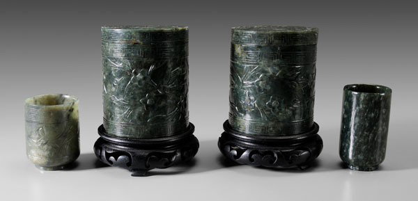Four Pieces of Jade: Chinese, late 19th/early 20th century: two cylindrical lidded boxes, dark green with white inclusions, bird in prunus trees within fretwork borders, 3-3/4 x 3-1/8 in., with wood stands, [minor chips o