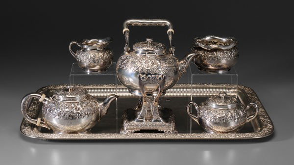 Tiffany Sterling Tea Service: American, 1873-1891: 13-1/4 in. kettle on stand with matching teapot, creamer, covered sugar, waste, band of floral and fern repoussé with wave edge, flattened ball finial, shaped ivory spacers, mono