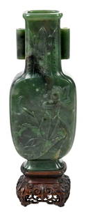 Chinese Jade or Hardstone Arrow Vase: mottled spinach green color with variations of black and white throughout, raised on stepped base, of flattened form, decorated with a lotus flower, the neck decorated with repeating palm leaves and