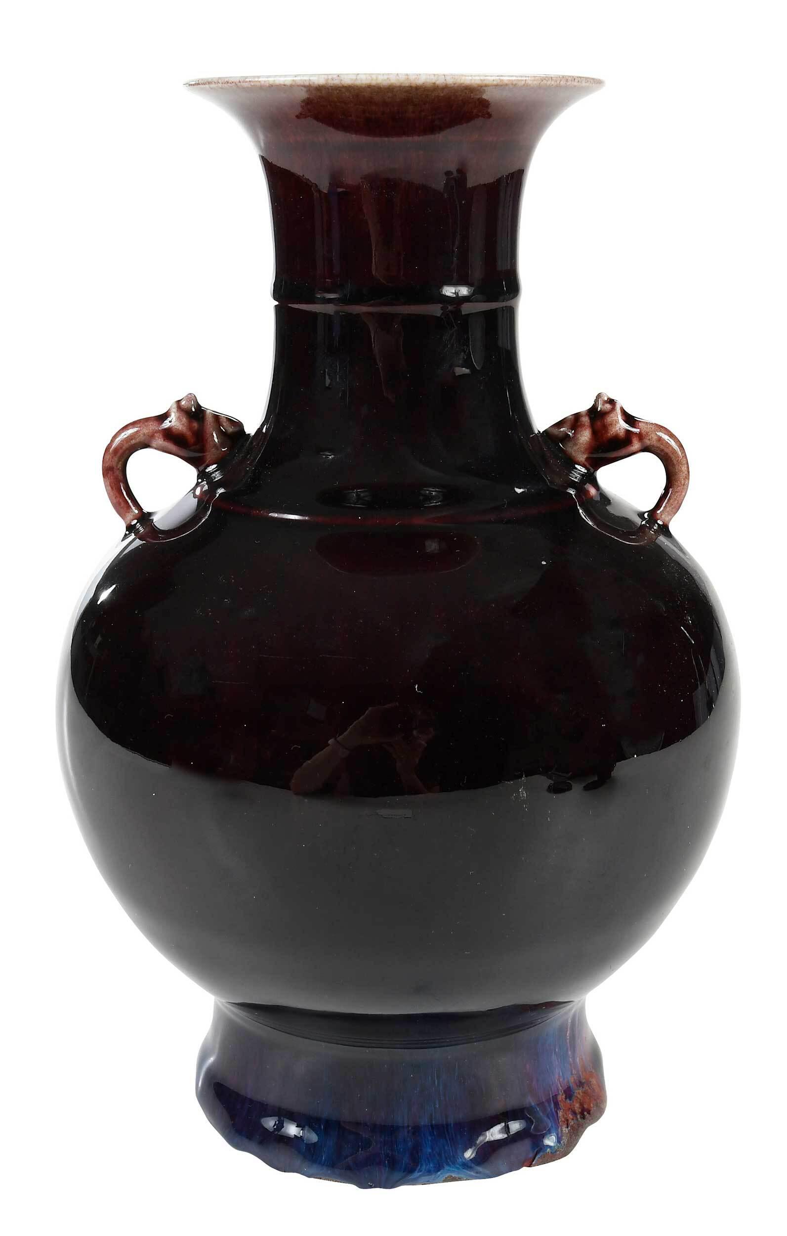 Chinese Sang de Boeuf Vase: of baluster form, deep red with purple base, two applied handles, flared rim, circular base, drilled, 11 in.