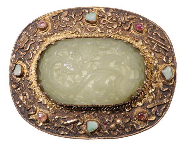 Chinese Jade Plaque: Qinglong Dynasty, even translucent light celadon color, curved and domed oval, carved with sinuous dragon among flowering vines, set in a gilt silver surround embossed with symbols of The Eight Immort