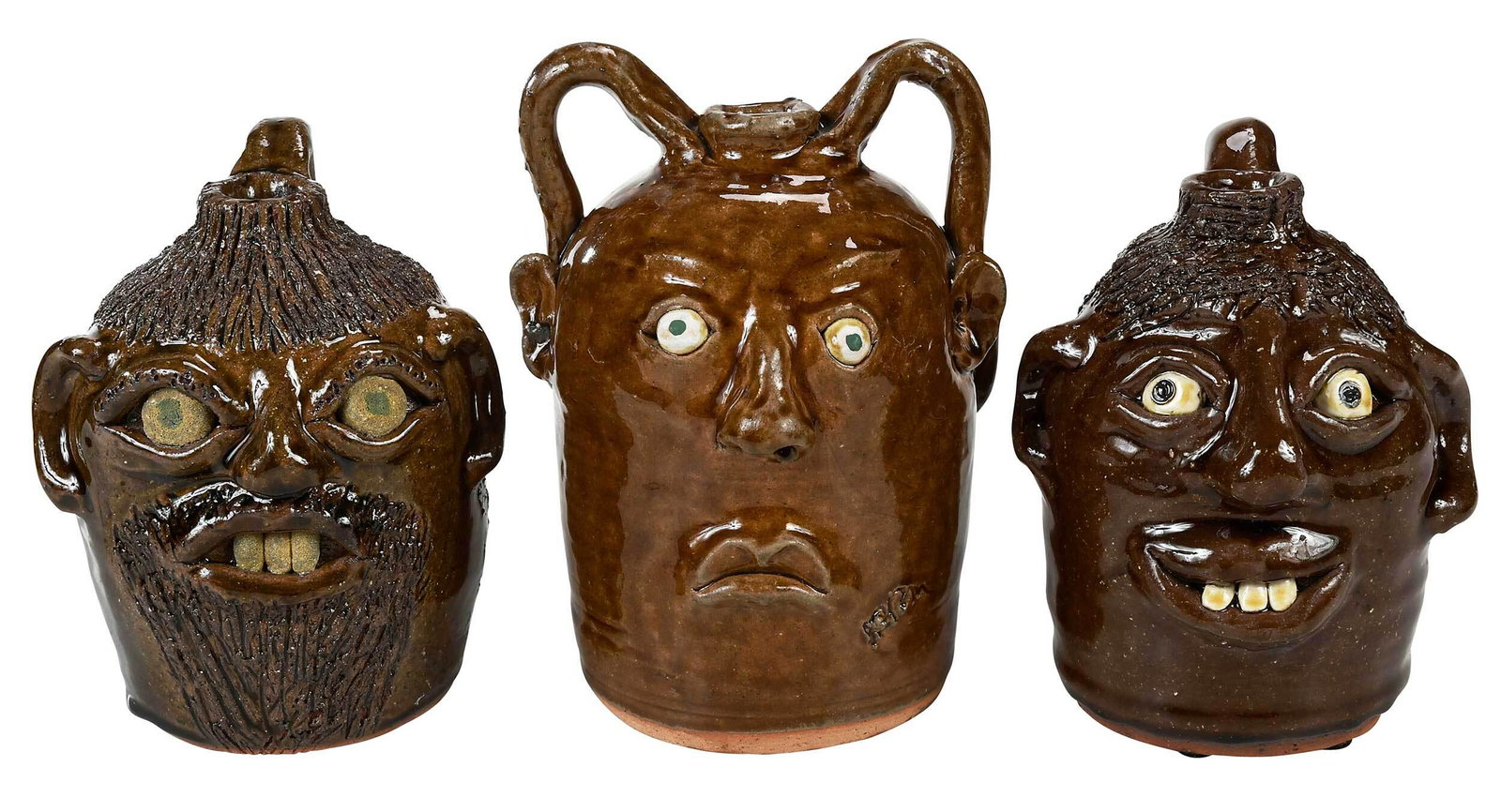 Three Reggie Meaders Face Jugs: (White County, Georgia, 1916-2009) brown alkaline glazes to all jugs, all with applied facial features, inset kaolin eyes and clay teeth, two with incised articulated hair, one with facial hair, short