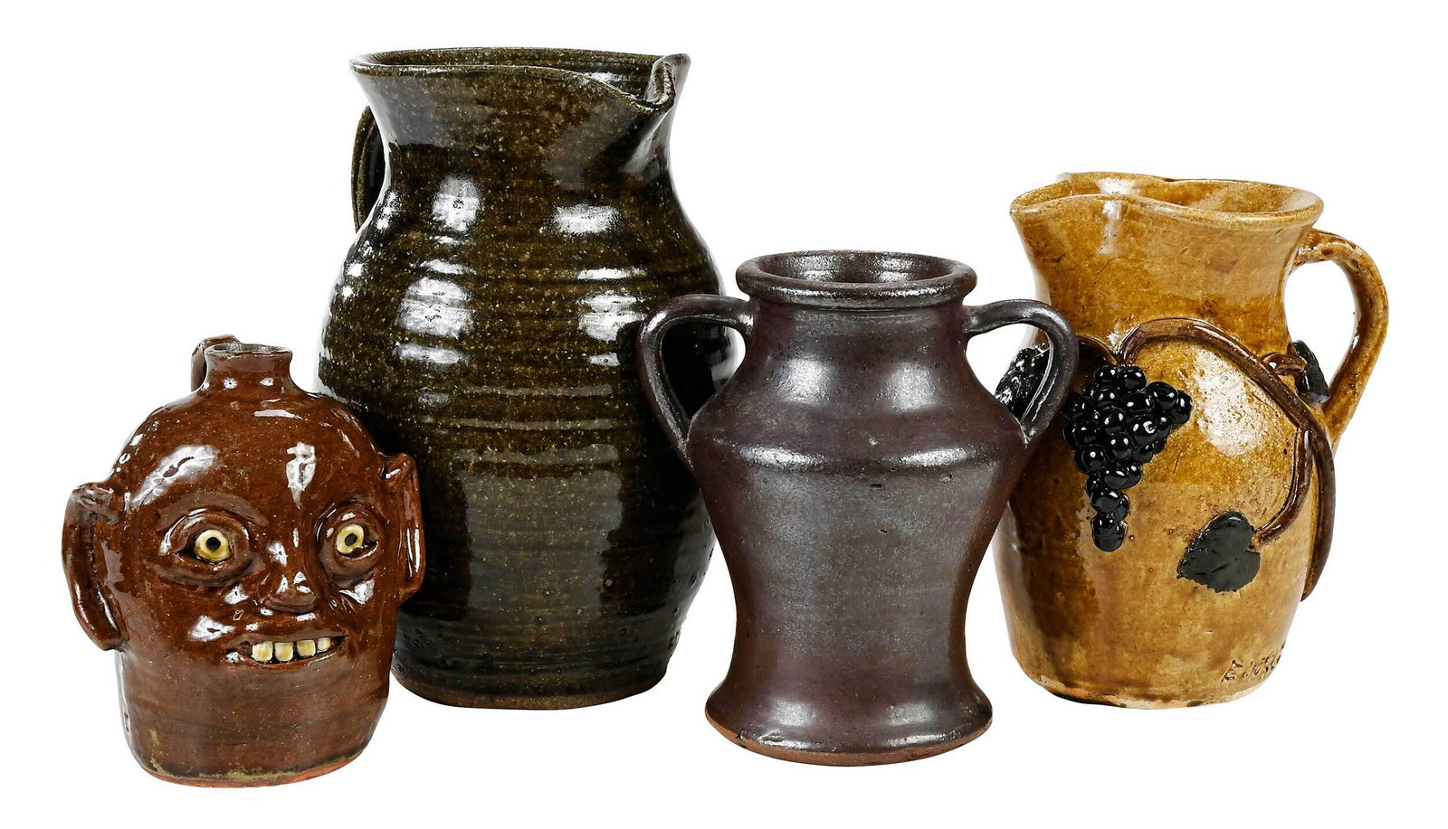 Four Pieces of Georgia Pottery: runny green alkaline glazed pitcher, signed "Anita Meaders" on base, 10 in.; two handled Albany slip glazed vase, signed "A.G. Meaders 1986" on base, 7-1/4 in.; brown glazed pitcher with applied color