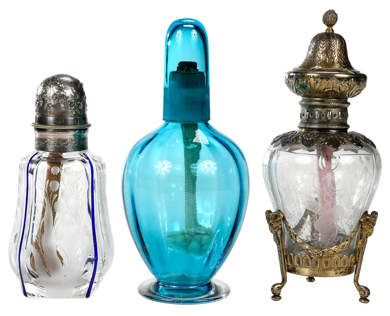 Three French Glass Burner Diffusers: early 20th century, comprising: clear glass burner, sides of glass engraved with flowers, torches, quiver with arrows, and hats, French silver mounts including collar with acanthus band, hinged cap an