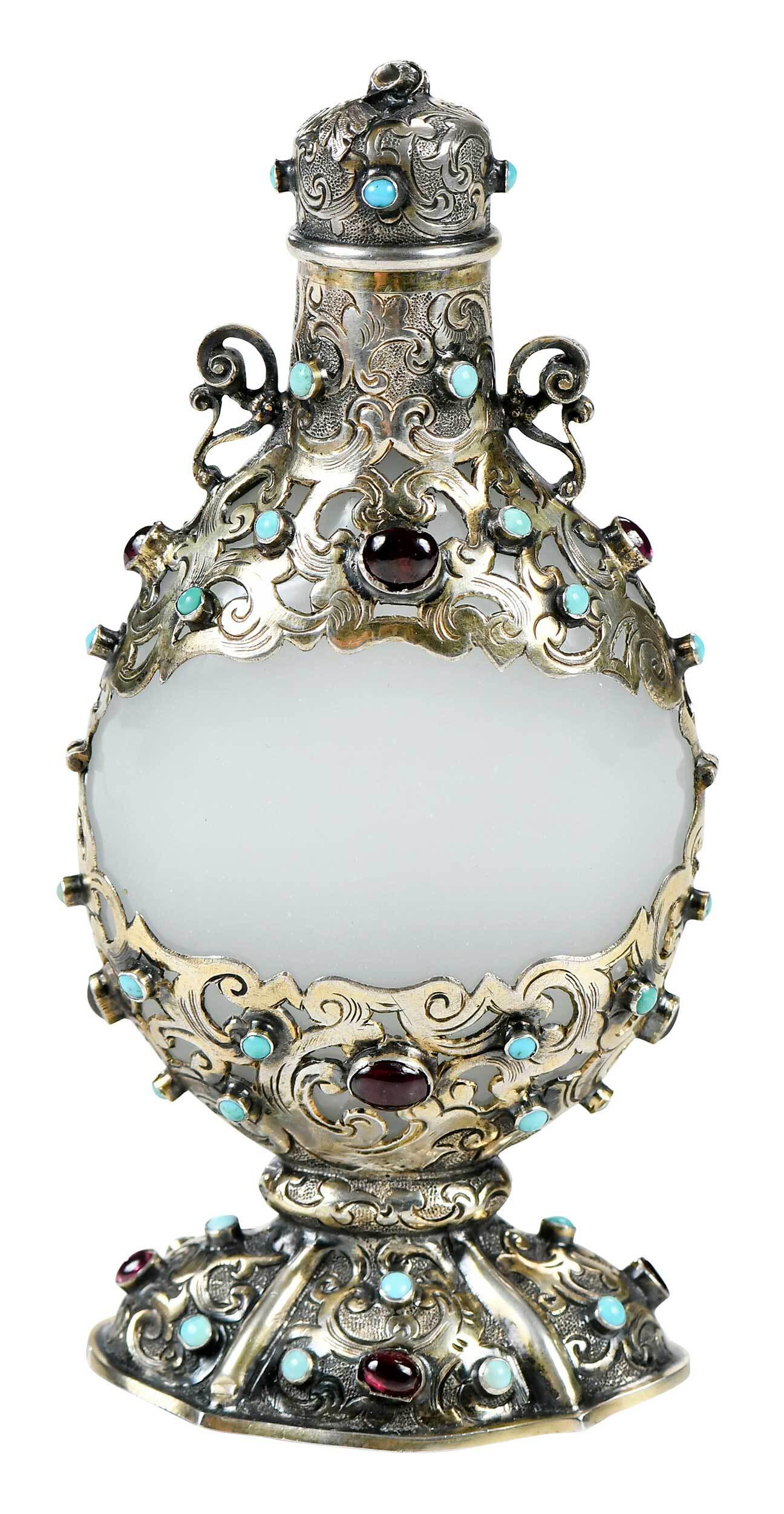 Austro Hungarian Vermeil and Gemstone Mounted Perfume: 19th century, clambroth glass, of flattened circular form, oval base, openwork silver mounted with turquoise and garnet stones, scrolled handles, hinged lid with stick form finial, silver unmarked, te