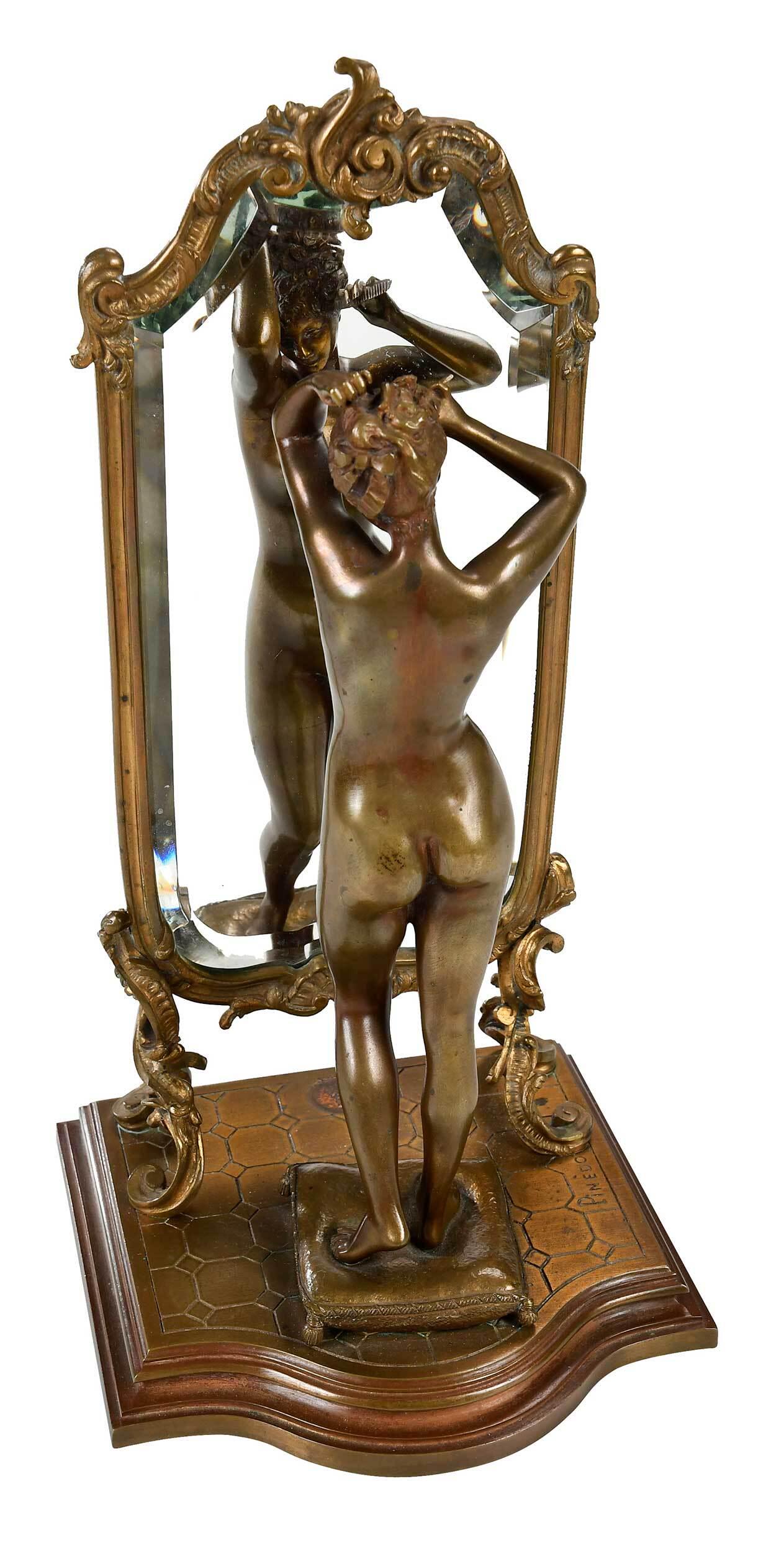 Emile Pinedo Bronze: (French, 1840-1916) Woman Combing Hair in Front of a Mirror, signed on base "Pinedo", stamped verso mirror "Pinedo/Paris", with foundry stamp, patinated bronze, 13-1/2 x 6-3/4 x 6-1/2 in. Provenance: